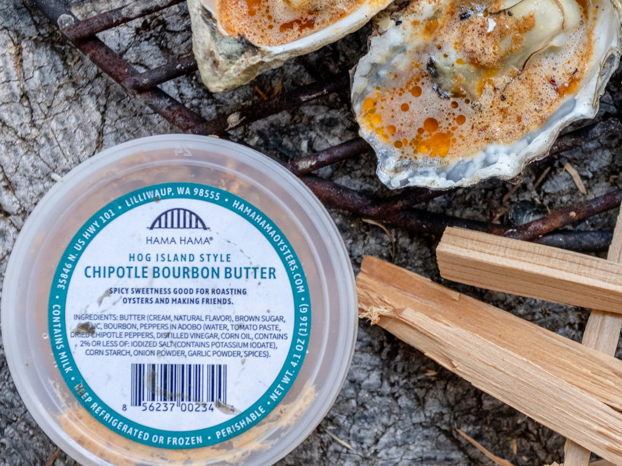 top down view of Hama Hama Oyster Company's house made chipotle bourbon butter in a plastic tub next to grilled oysters topped with the butter 