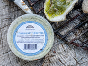 top down view of Hama Hama Oyster Company's house-made stinging nettle butter in a plastic tub next to a grilled oyster with the butter